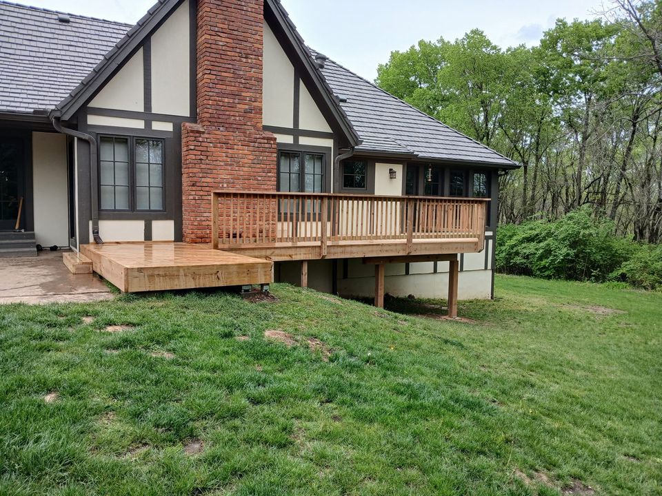 Wood deck with perimeter railings and steps beside a home